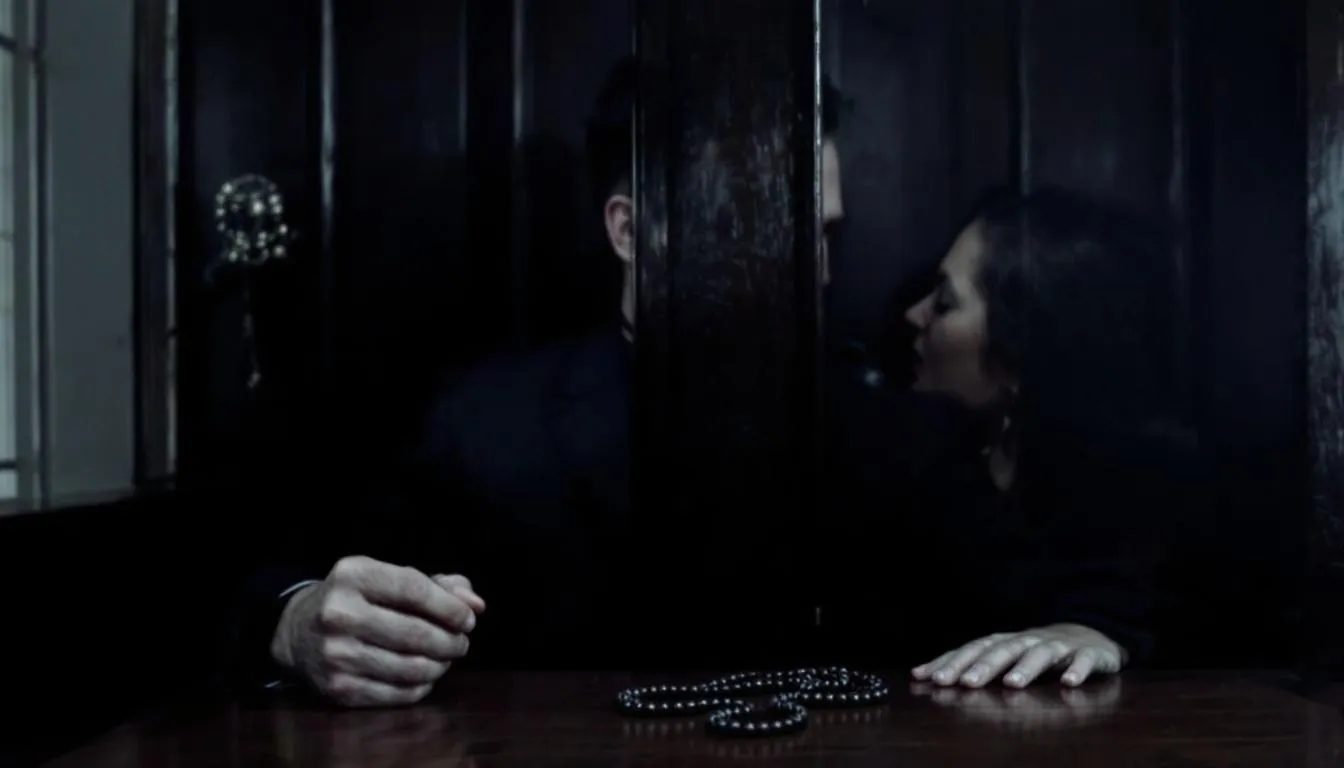 In a dimly lit confessional, a masked figure representing a "priest" grips a rosary tightly while a "sinner" whispers her taboo fantasy through the screen, creating an atmosphere of sexual tension and role play that hints at a power dynamic between them. The scene evokes a sense of intrigue and excitement, embodying the essence of erotic role play scenarios.