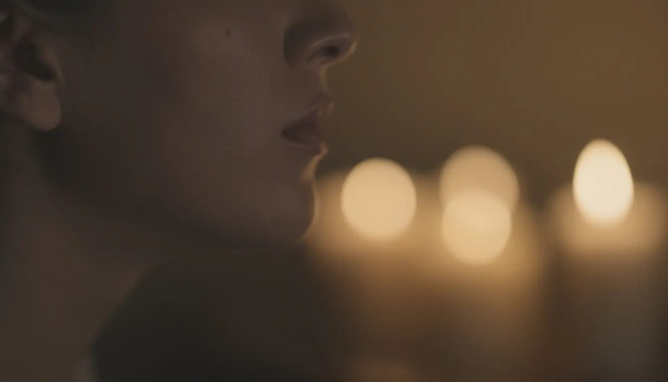 A close-up of a person's lips nearly brushing against their partner's ear, poised to whisper intimate secrets that build sexual tension. The soft, blurred candlelight in the background enhances the anticipation of this intimate moment, where the air is thick with unspoken desires and the promise of sexy talk.